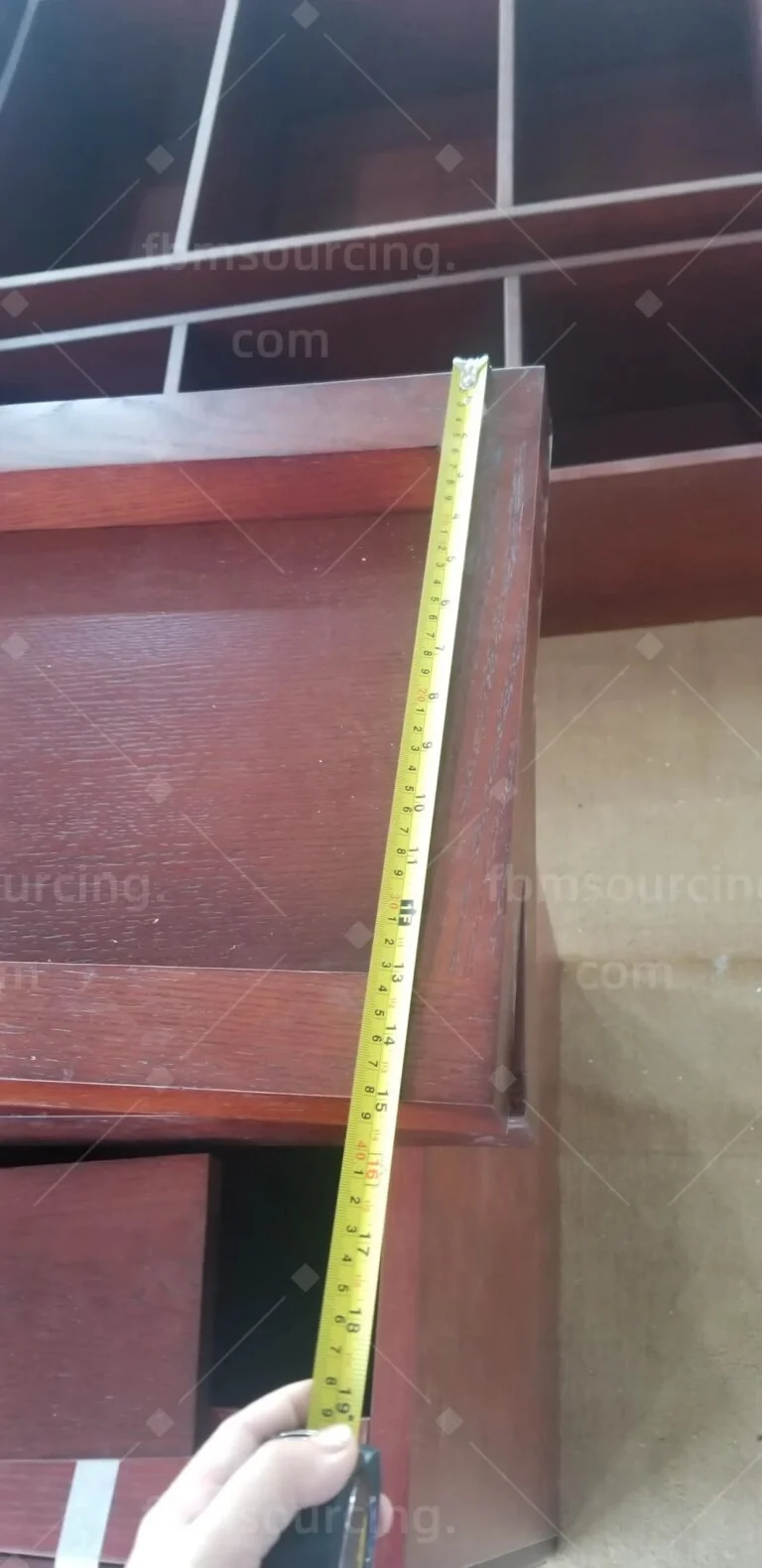 Timber cabinet side measured with a tape at the inspection
