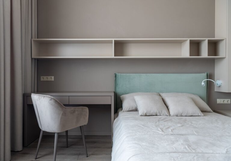 Compact bedroom with bed, built-in desk and shelving
