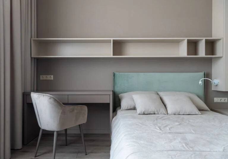 Compact bedroom with bed, built-in desk and shelving