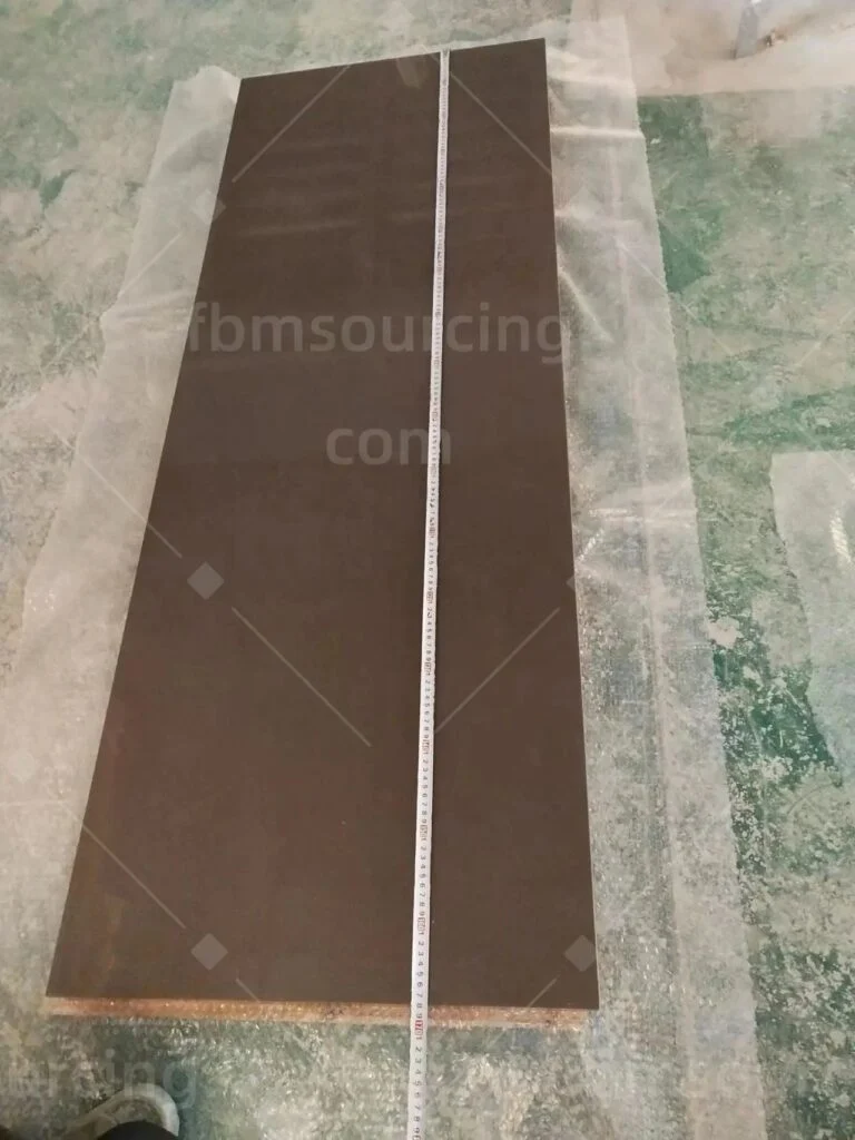 Dark wardrobe panel measured with a tape at the inspection