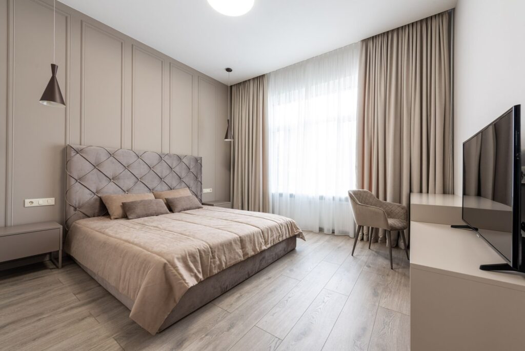 Hotel guestroom with walnut panelling and upholstered headboard