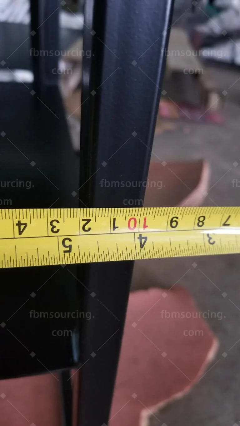 Tape measure across a black steel frame member