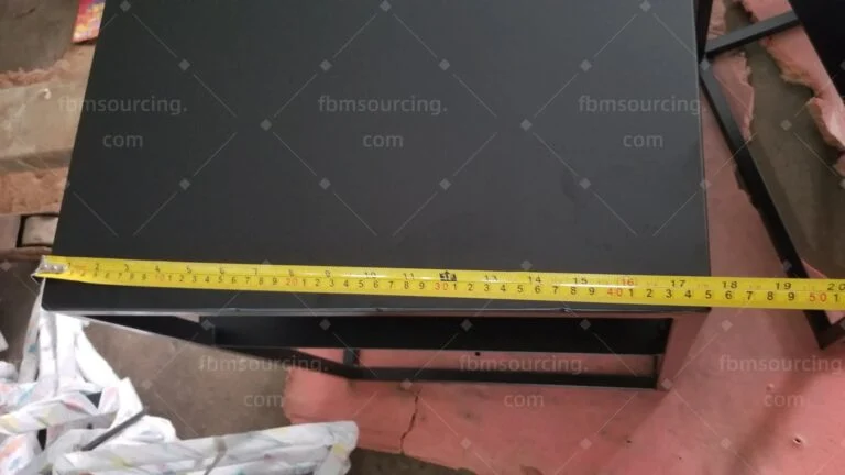 Black side table top width measured with a tape