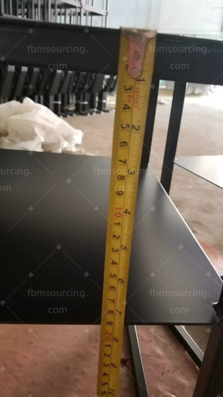 Black side table height measured with a tape