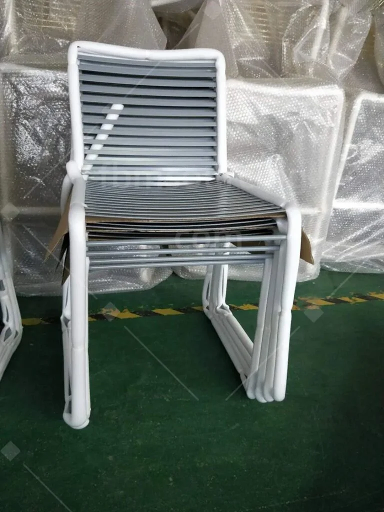 White wire chairs stacked at the inspection