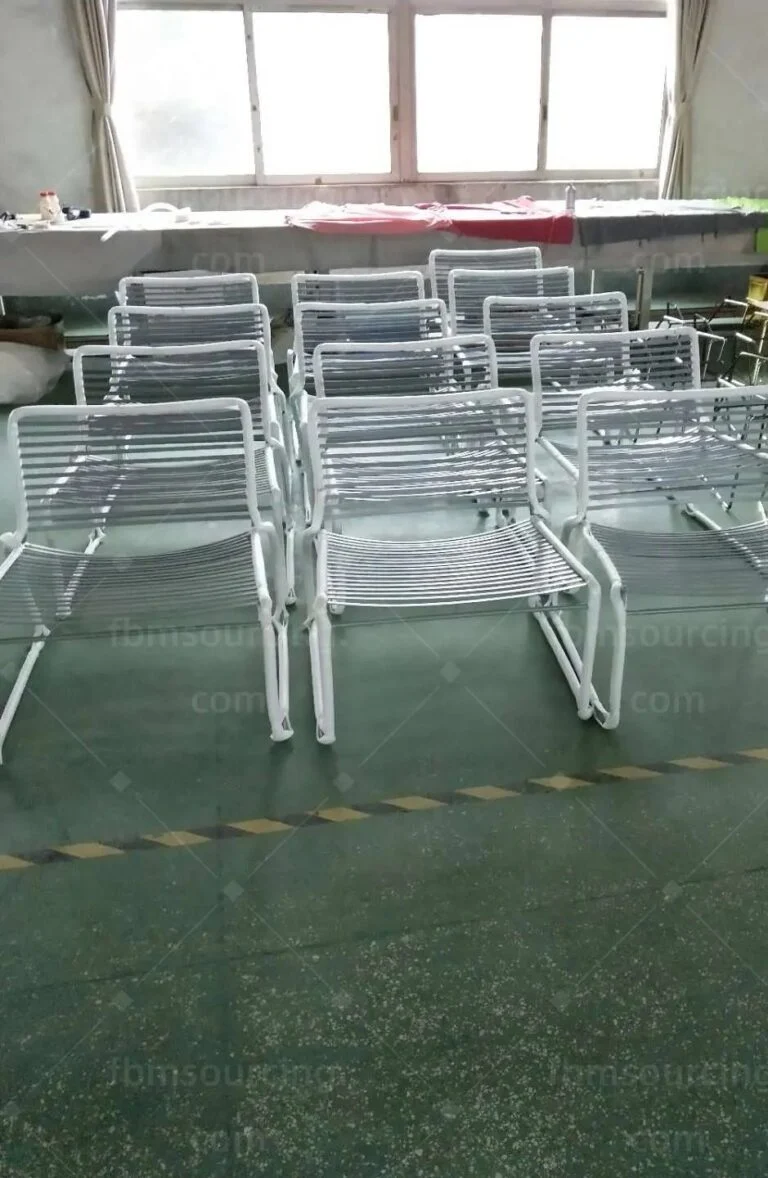 Rows of white wire chairs set out for the inspection