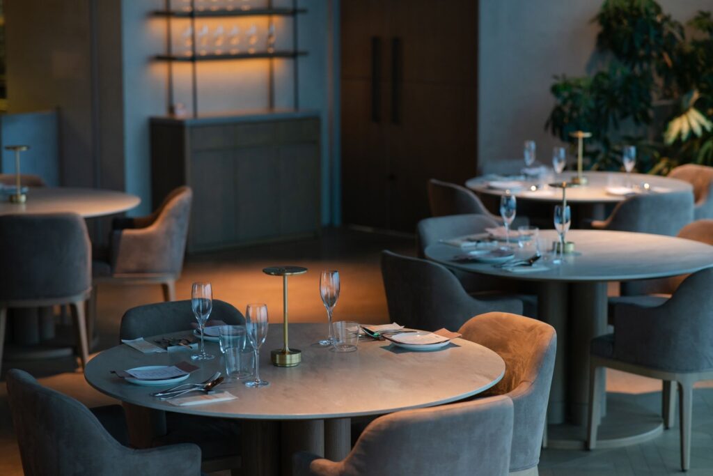 Restaurant with round stone tables and upholstered tub chairs