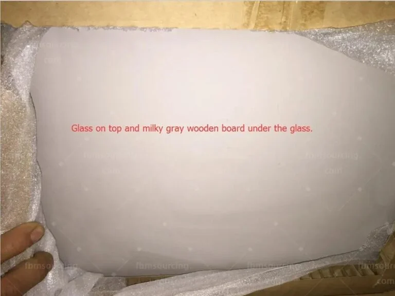 Glass-topped table panel over a grey board in its packing